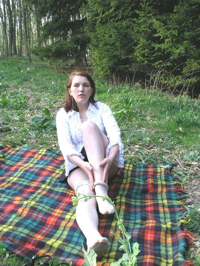 Junge Frau sitzt auf Picknickdecke